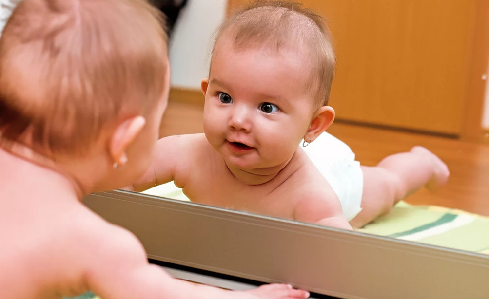 ребенок смотрит на себя в зеркало